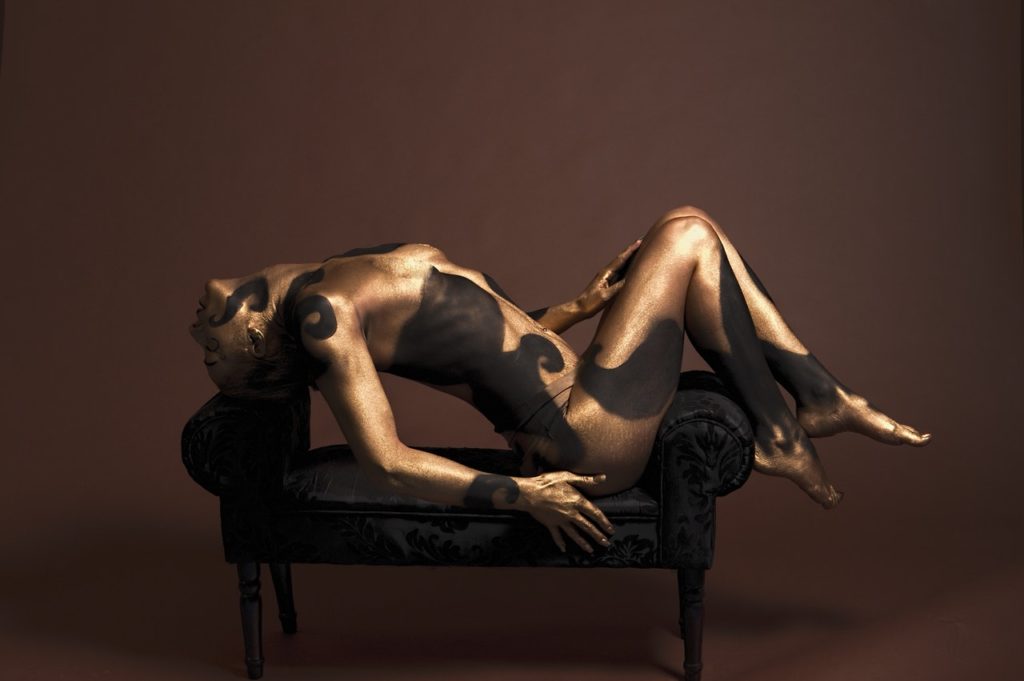 mujer con el cuerpo pintado con pintura corporal en postura provocativa