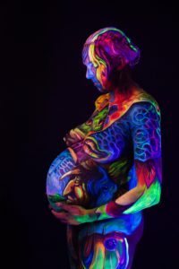 mujer embarazada con pintura corporal fluorescente
